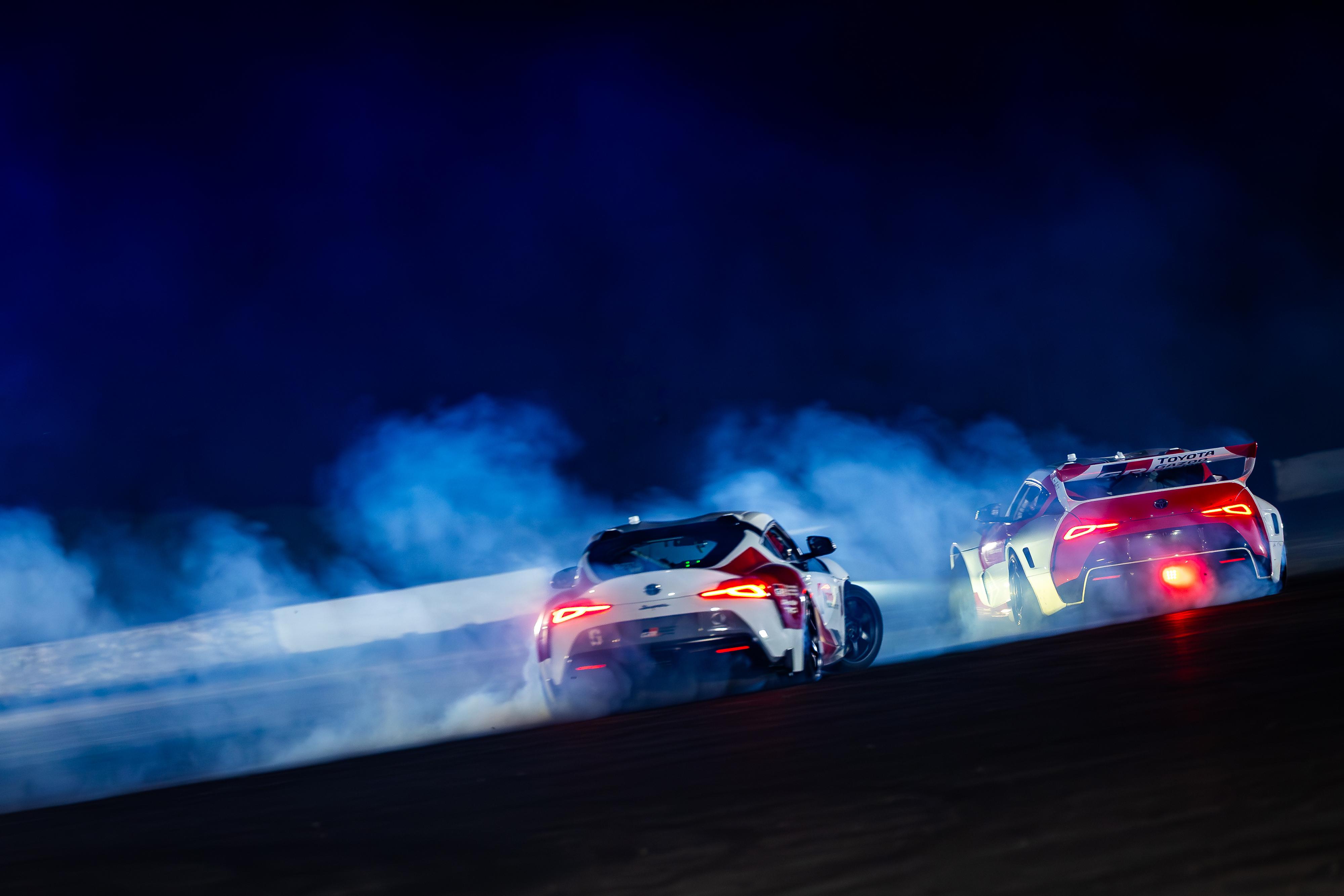 Action shot of Toyota Supras tandem drifting autonomously.